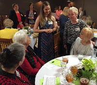 scholarship winner being introduced to women at a table